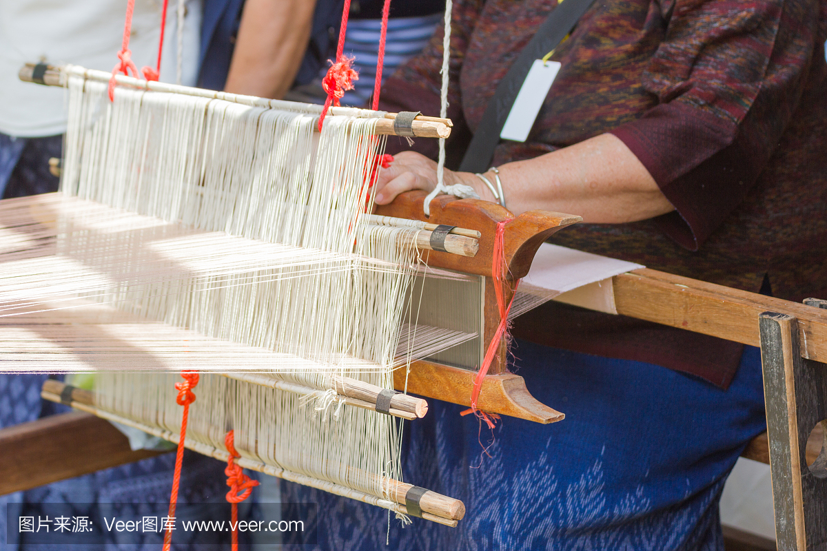 老年妇女正在使用机器-家用织机织造-在泰国进行自制丝绸或纺织品生产